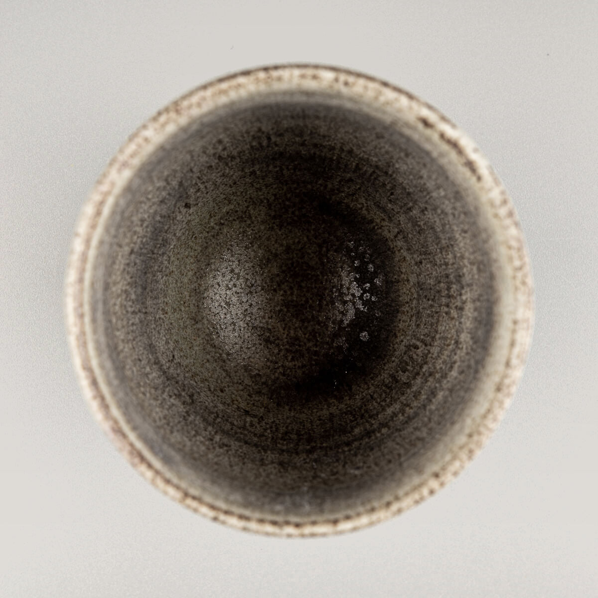 Top view of artisanal pottery cup with unique glaze finish, perfect for tea, coffee, and collectible stoneware.