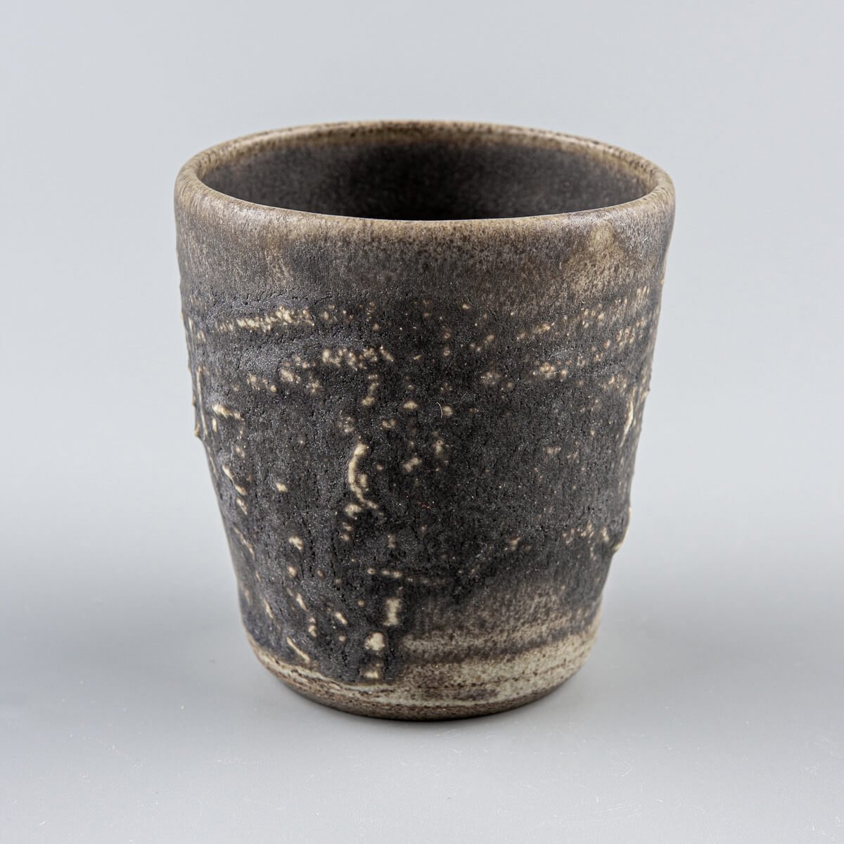 Rustic dark stoneware mug with hakeme texture and deep olive-green glaze, ideal for fine dining and home decor.