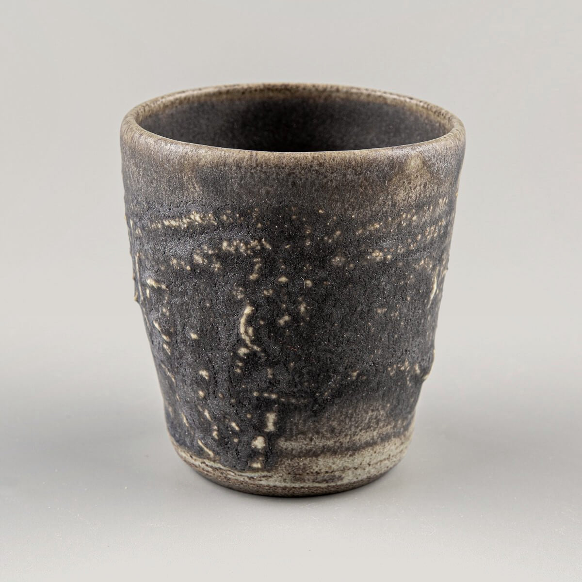 Rustic dark stoneware mug with hakeme texture and deep olive-green glaze, ideal for fine dining and home decor.