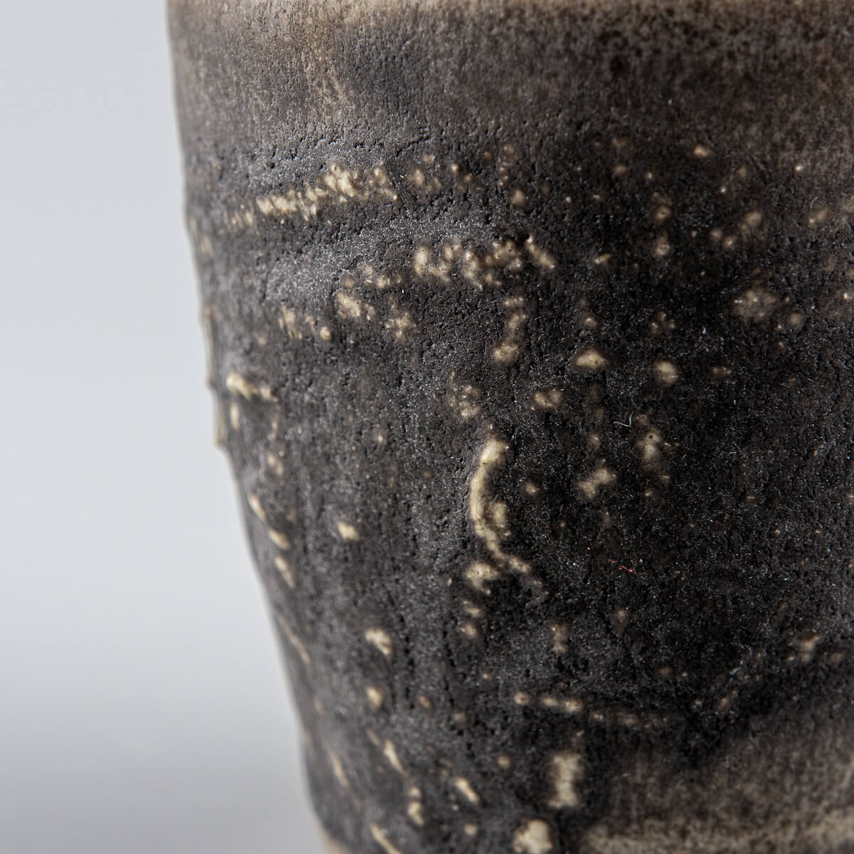 Detailed textured dark stoneware mug with earthy glaze, perfect for fine dining chefs and handmade decor.