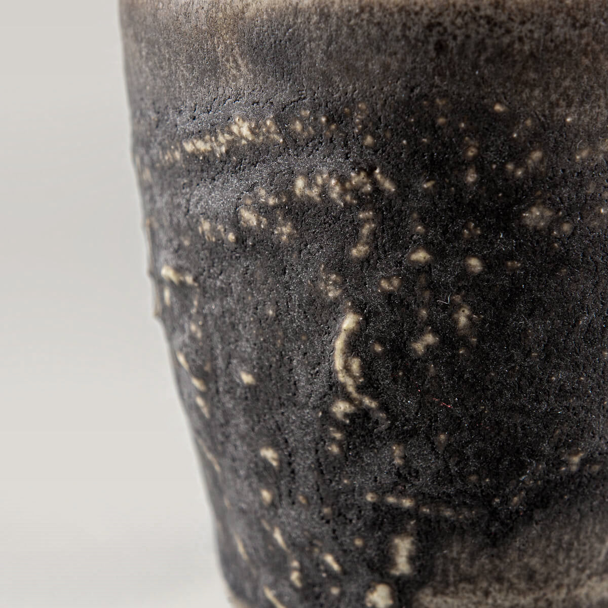 Detailed textured dark stoneware mug with earthy glaze, perfect for fine dining chefs and handmade decor.