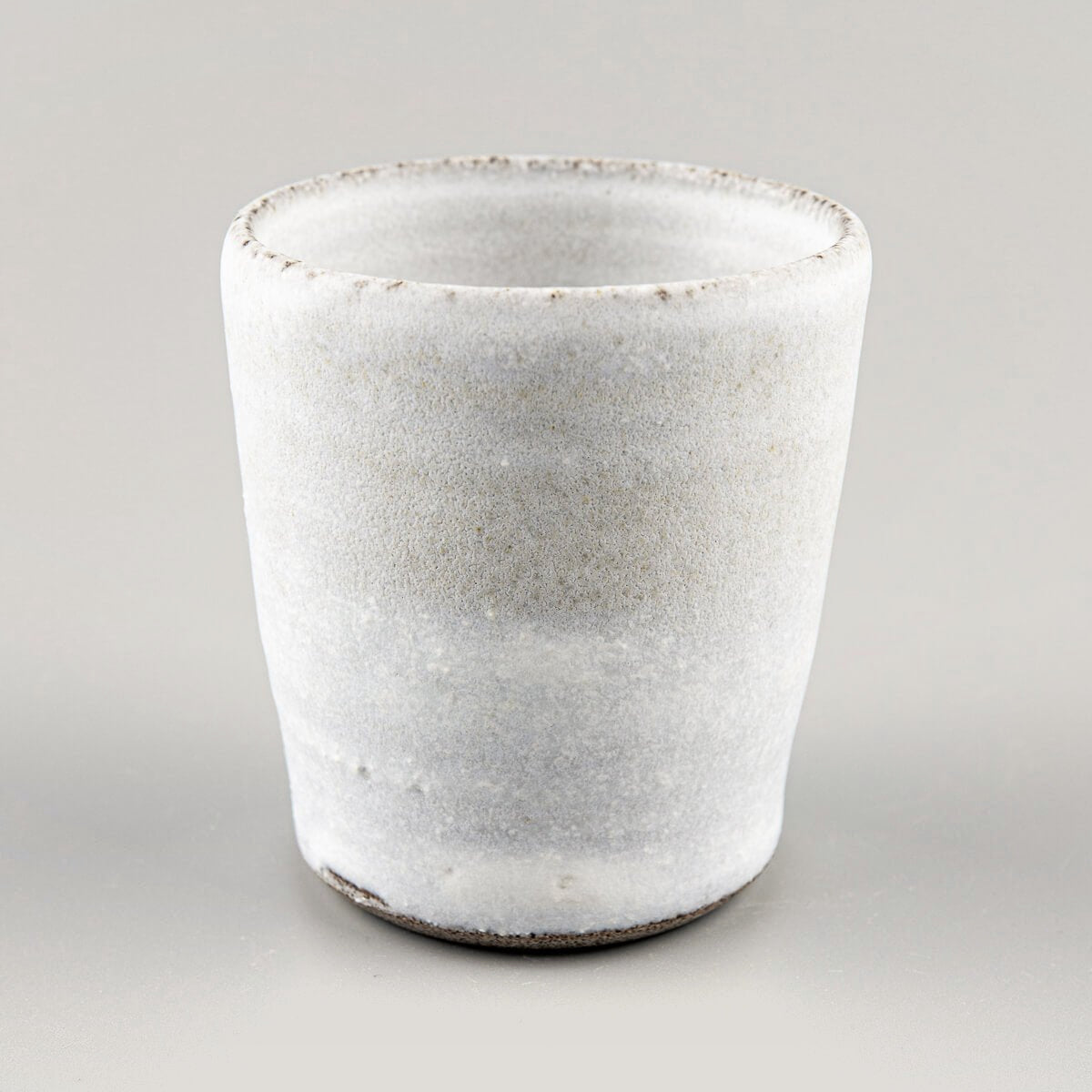 Elegant handmade ceramic cup in matte white finish, ideal for interior design and collectible pottery.