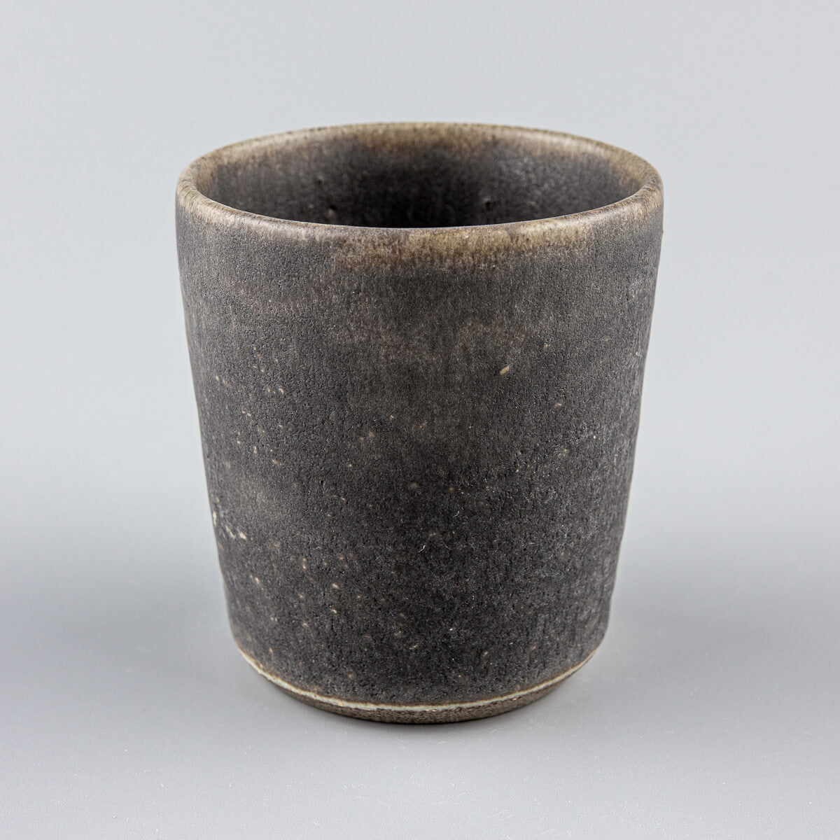 Minimalist stoneware pottery cup with dark olive glaze, perfect for tea, coffee, and matcha rituals.