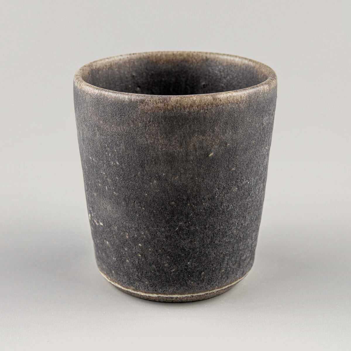 Minimalist stoneware pottery cup with dark olive glaze, perfect for tea, coffee, and matcha rituals.