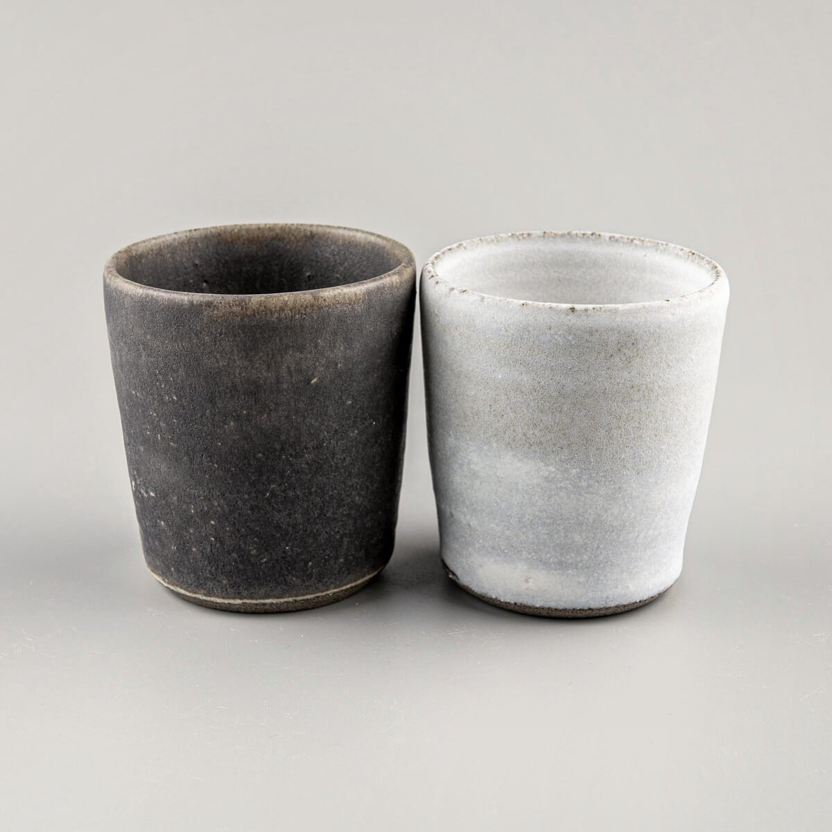 Handcrafted pottery cups with olive glaze and matte white finish for fine dining and home tableware.