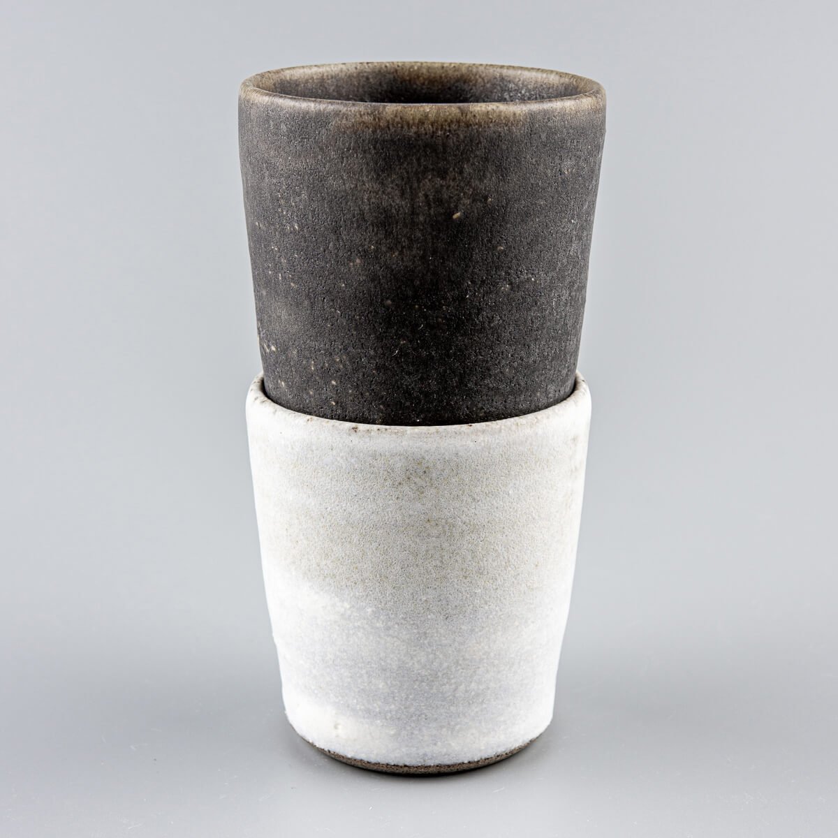 Pair of artisanal ceramic cups with contrasting finishes, designed for weddings and gift ideas.