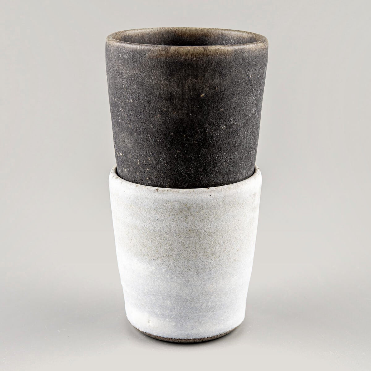 Pair of artisanal ceramic cups with contrasting finishes, designed for weddings and gift ideas.