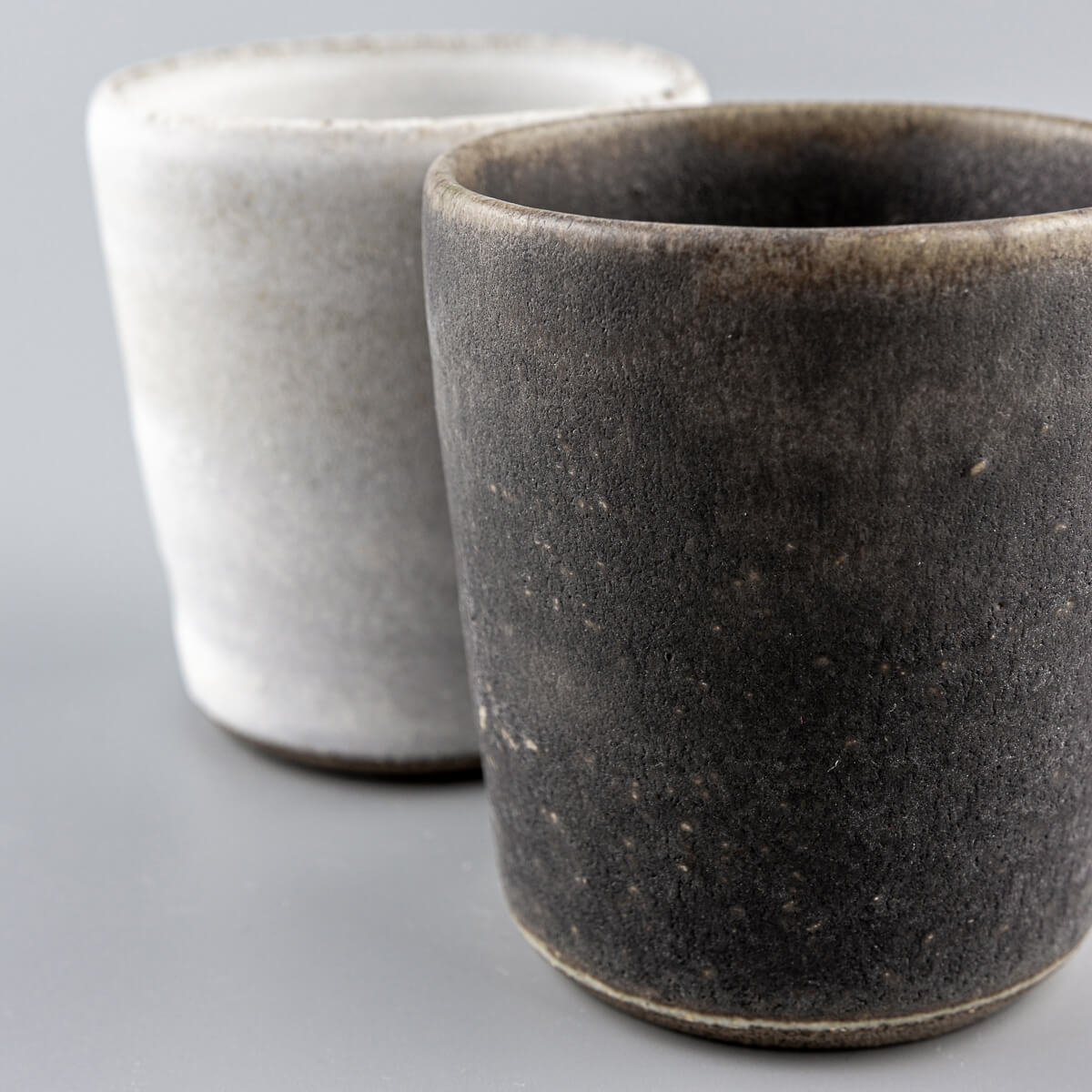Two handcrafted ceramic cups showcasing the hakeme technique, designed for culinary presentation.