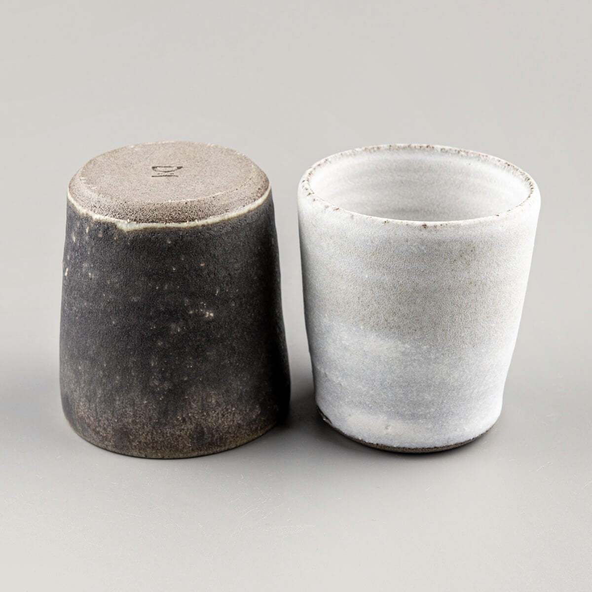 Top-down view of pottery cups showing elegant glaze contrast, ideal for culinary presentation.