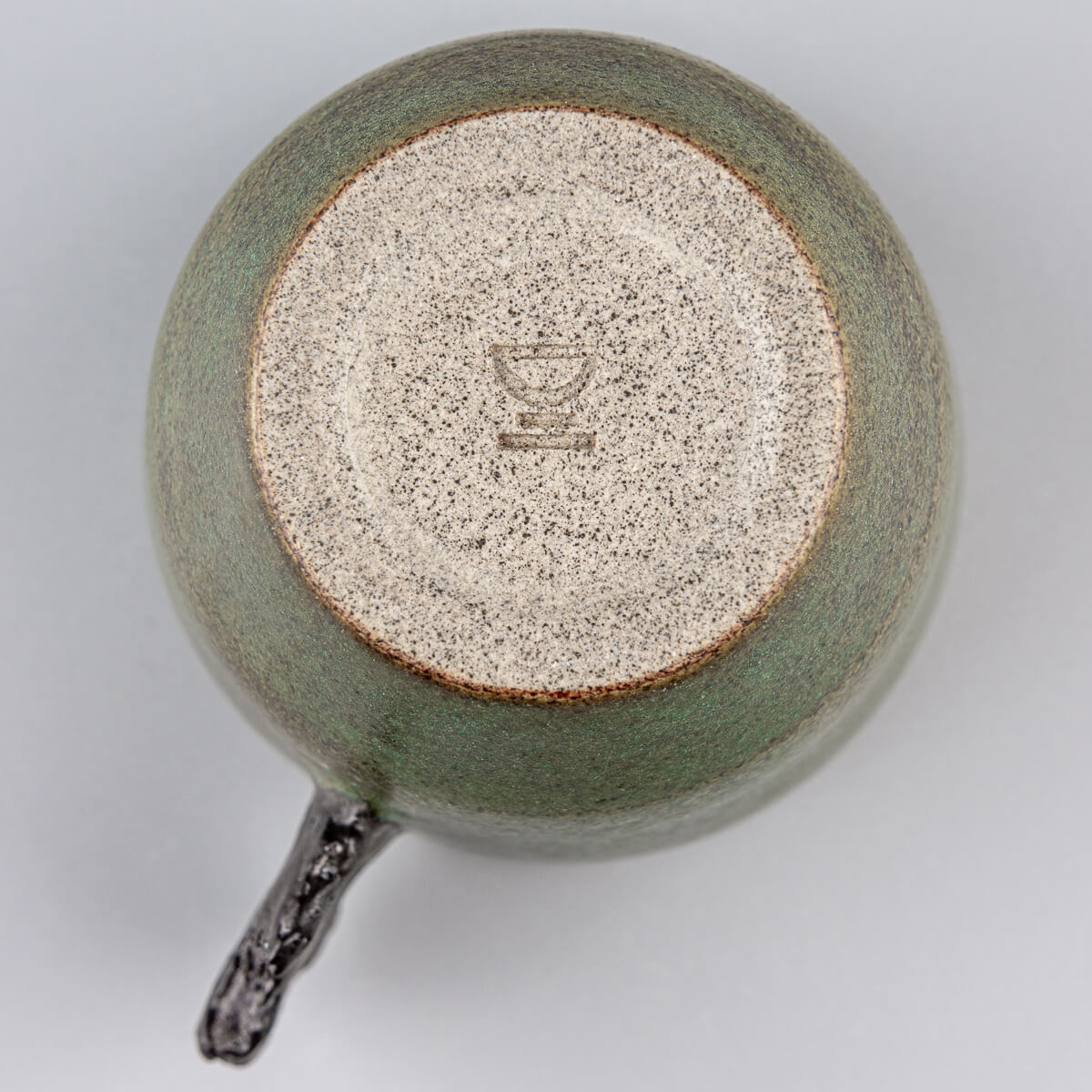Base detail of handcrafted pottery mug showing artisanal stoneware craftsmanship and limited edition design.