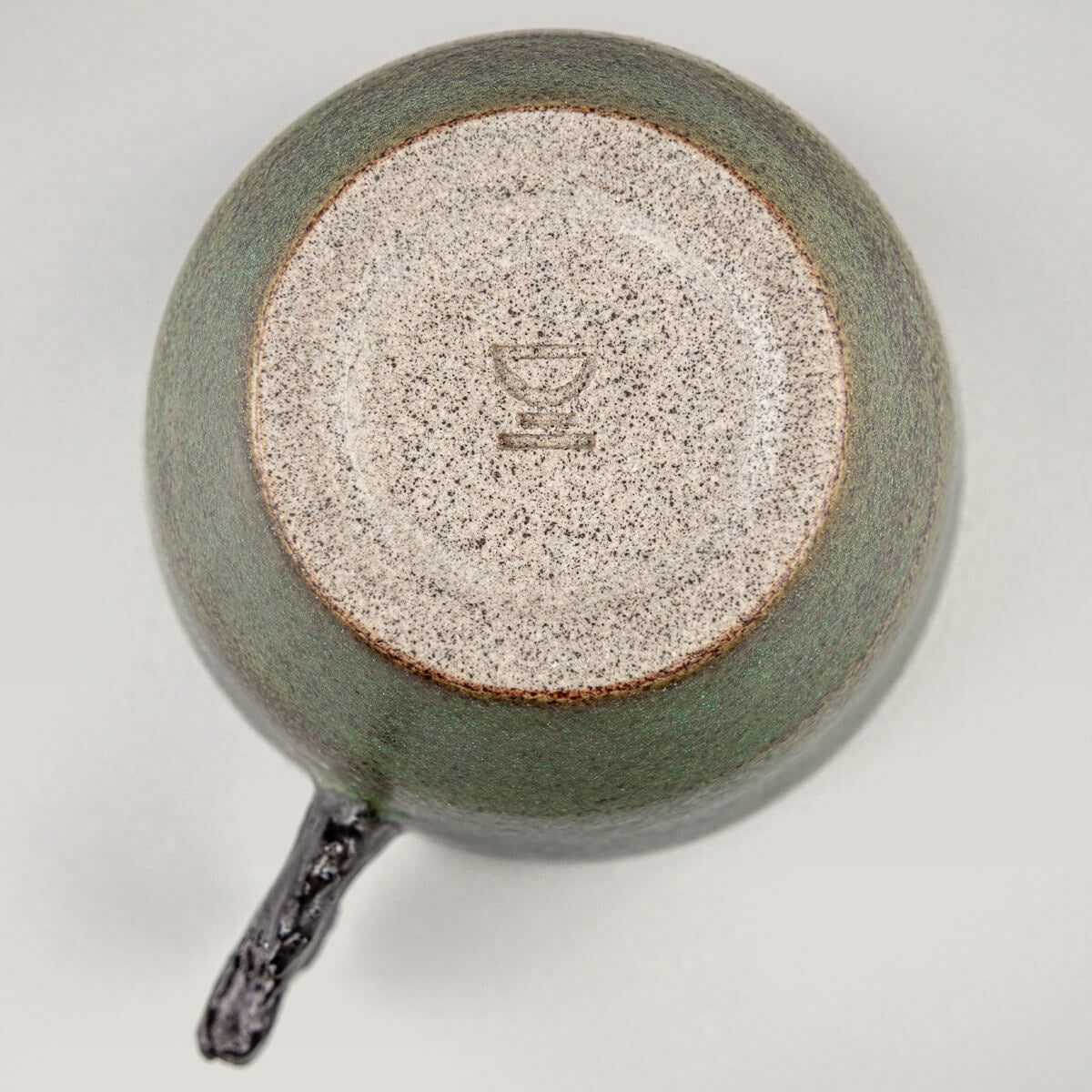 Base detail of handcrafted pottery mug showing artisanal stoneware craftsmanship and limited edition design.