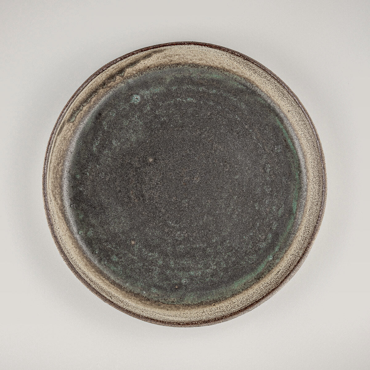 Handcrafted ceramic plate with olive-green matte glaze for fine dining and professional chefs.
