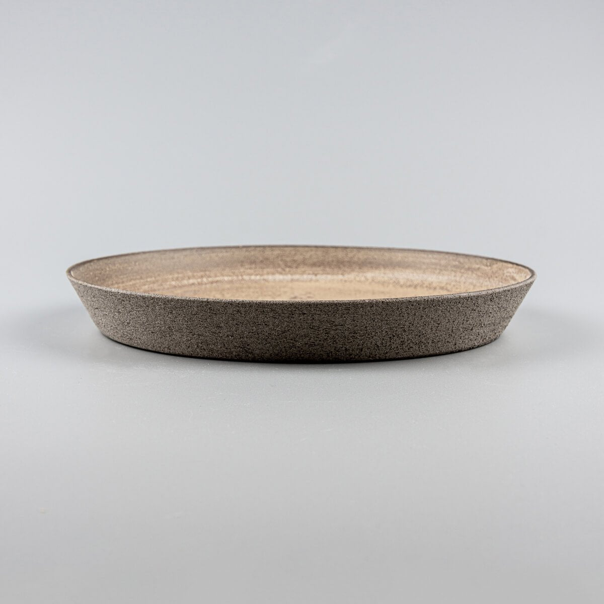 Elegant coupe-style stoneware dinner plate with raised curved edges for premium table settings.