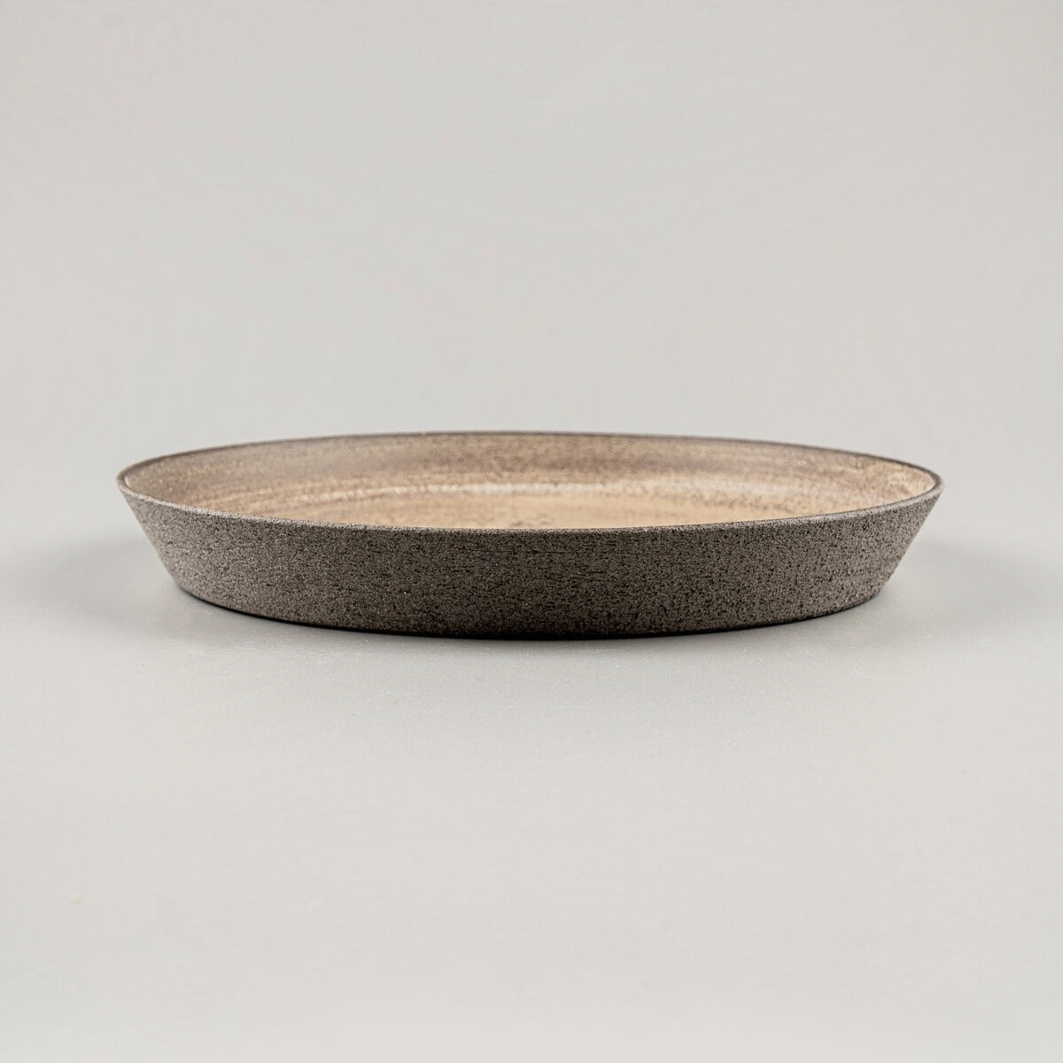 Elegant coupe-style stoneware dinner plate with raised curved edges for premium table settings.