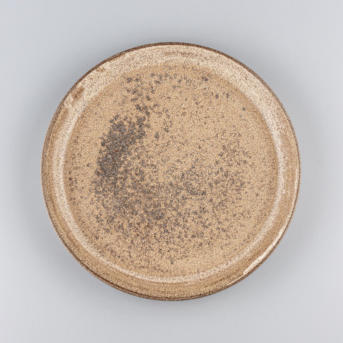 Overhead view of artisanal stoneware dinner plate with earthy glaze finish.