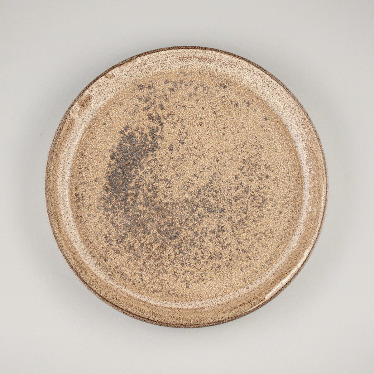 Overhead view of artisanal stoneware dinner plate with earthy glaze finish.