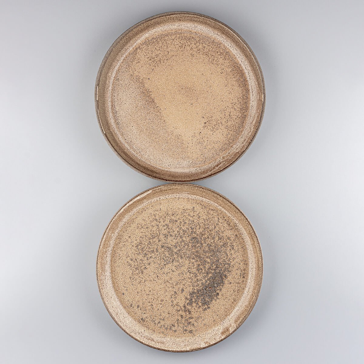Handcrafted stoneware dinner plate set with matte ocher glaze and natural clay base.