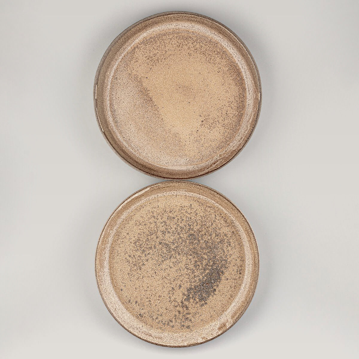 Handcrafted stoneware dinner plate set with matte ocher glaze and natural clay base.