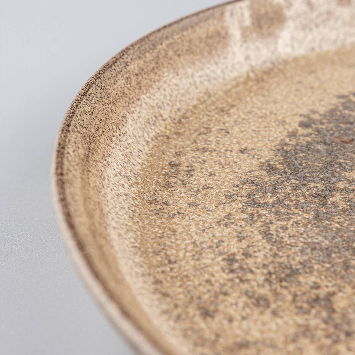 Close-up of plate rim showing natural clay texture.