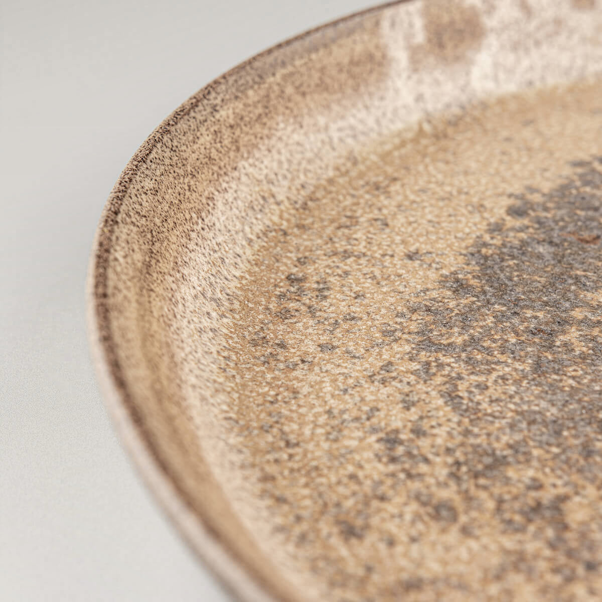 Close-up of plate rim showing natural clay texture.