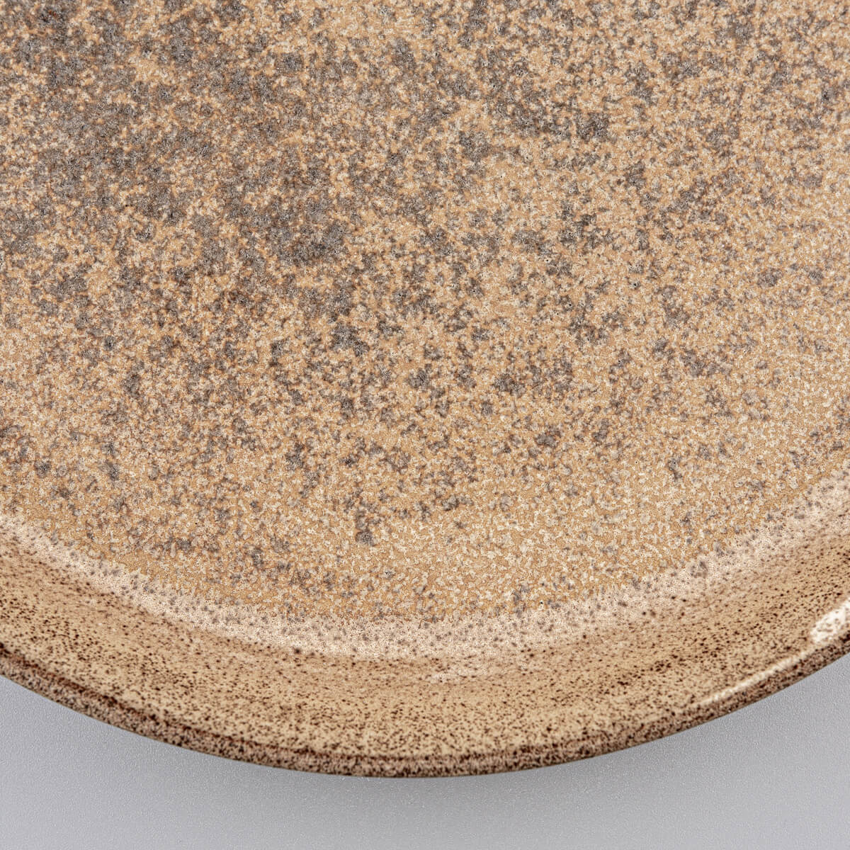 Textured center of stoneware dinner plate with artisanal glaze finish.