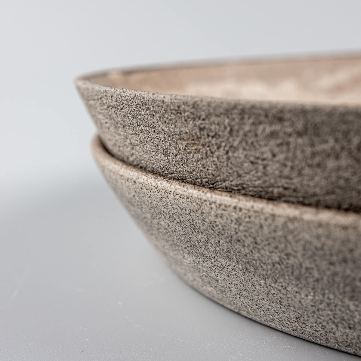 Side view of stacked stoneware plates for premium table settings.