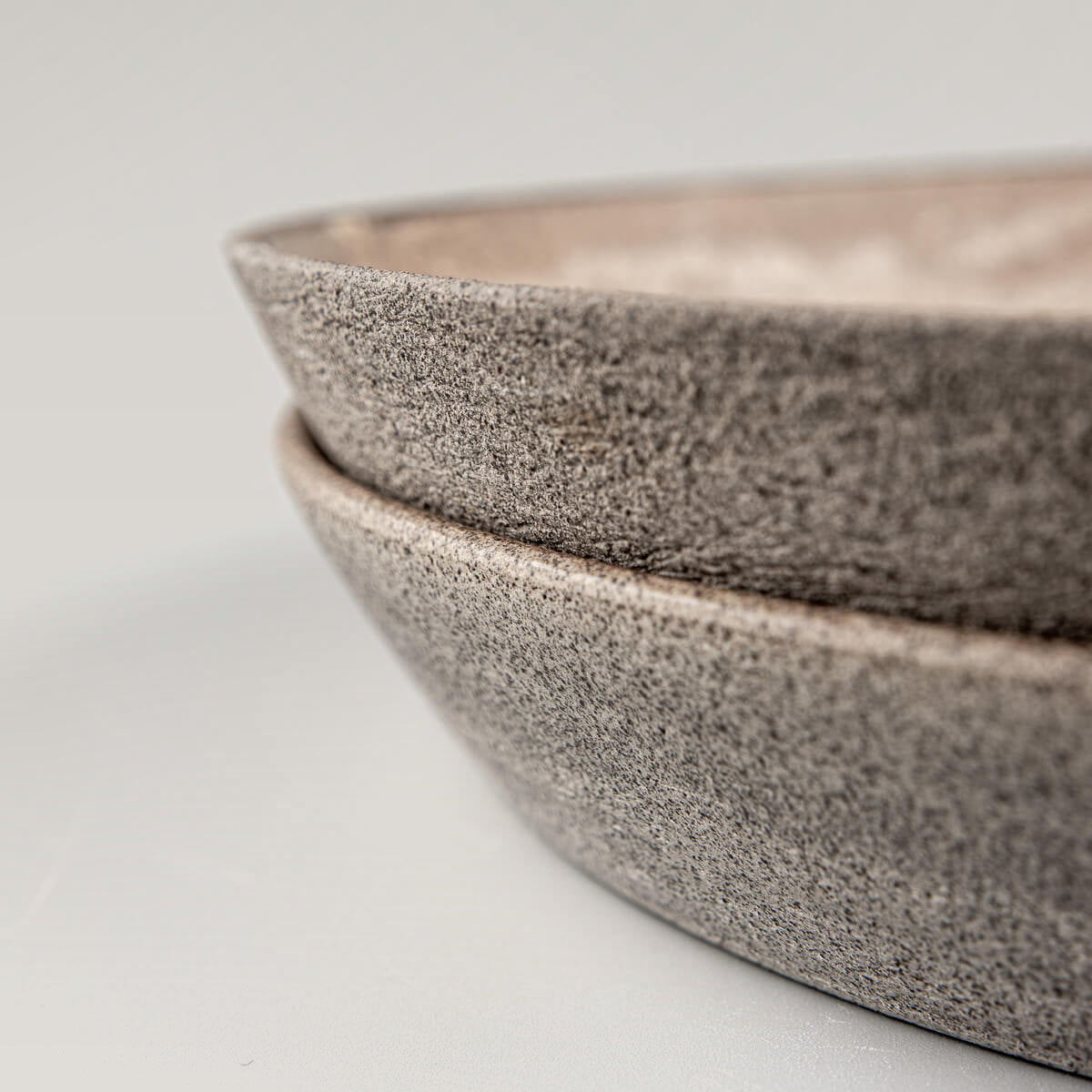 Side view of stacked stoneware plates for premium table settings.