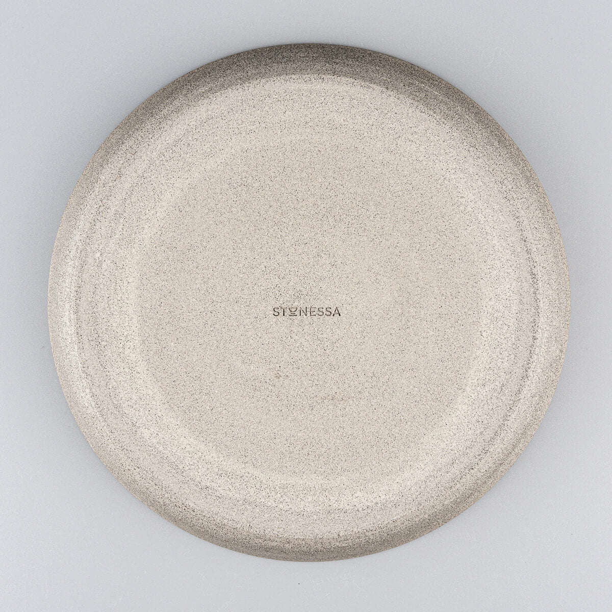 Overhead view of stoneware dinner plate with smooth central surface.