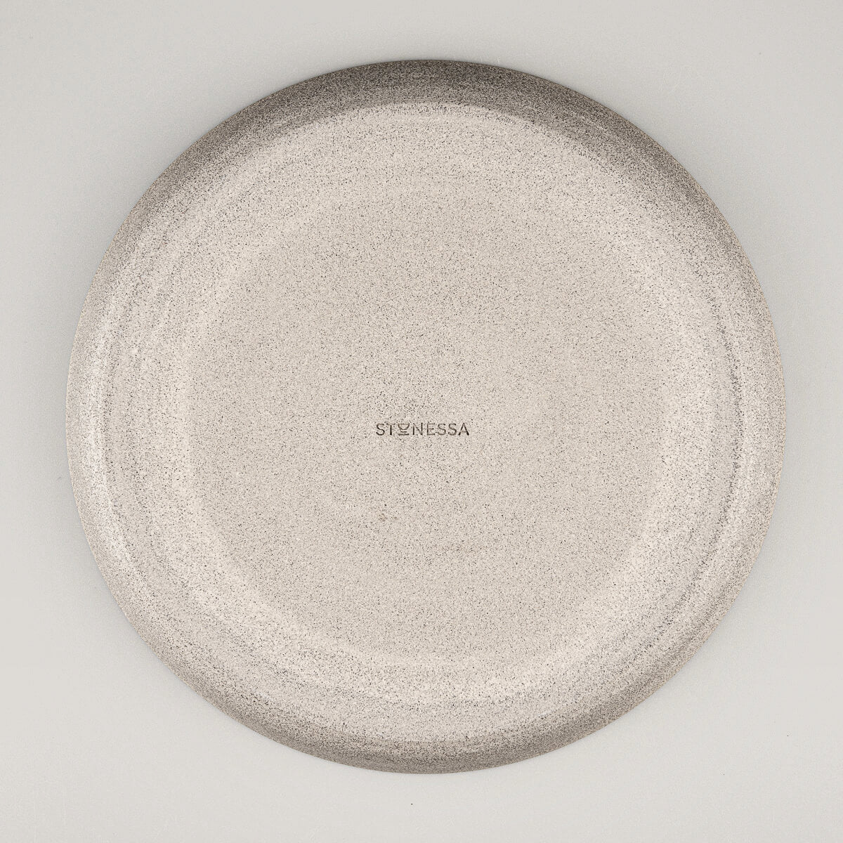 Overhead view of stoneware dinner plate with smooth central surface.