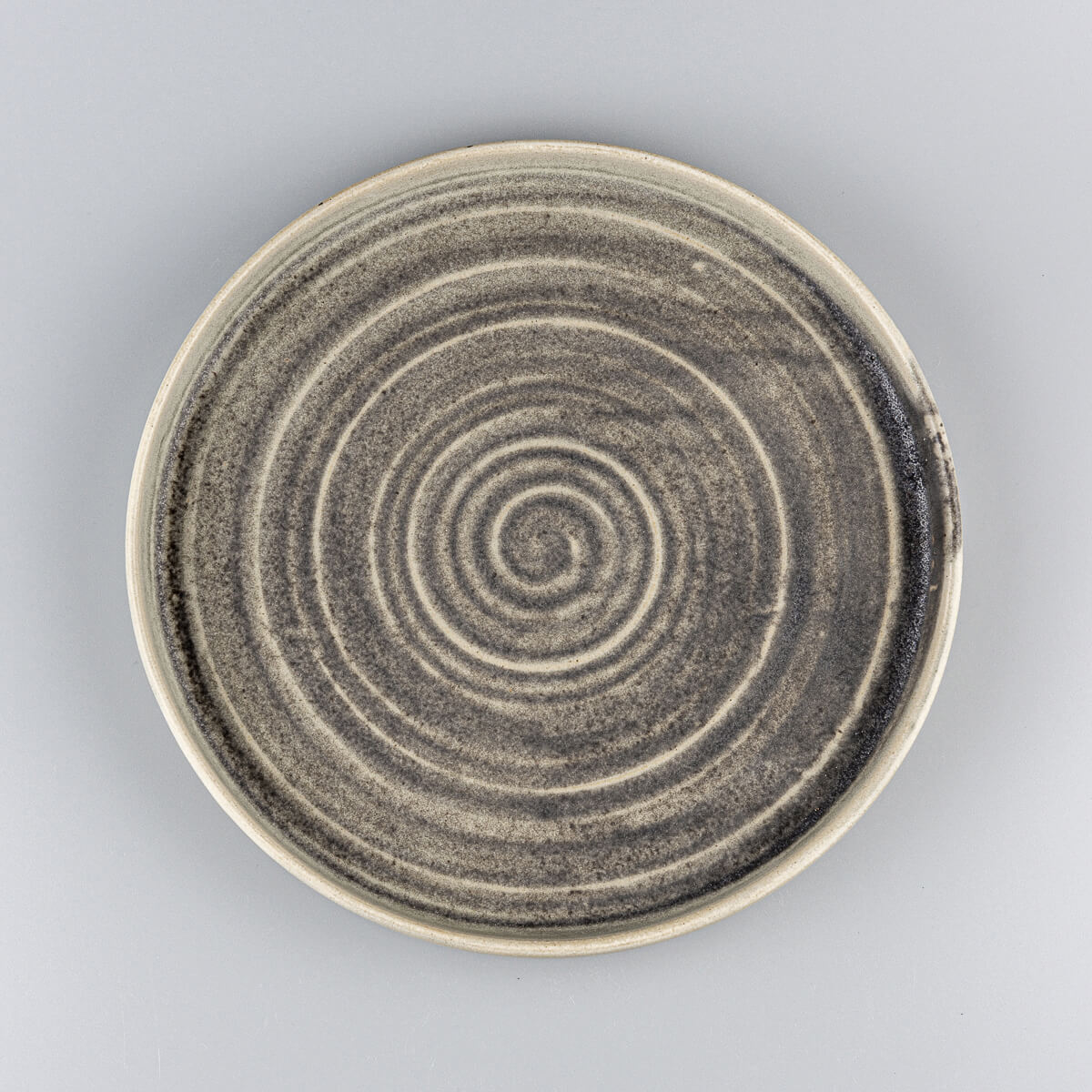 Elegant handcrafted ceramic plate with spiral design and matte olive green glaze for luxury dining.