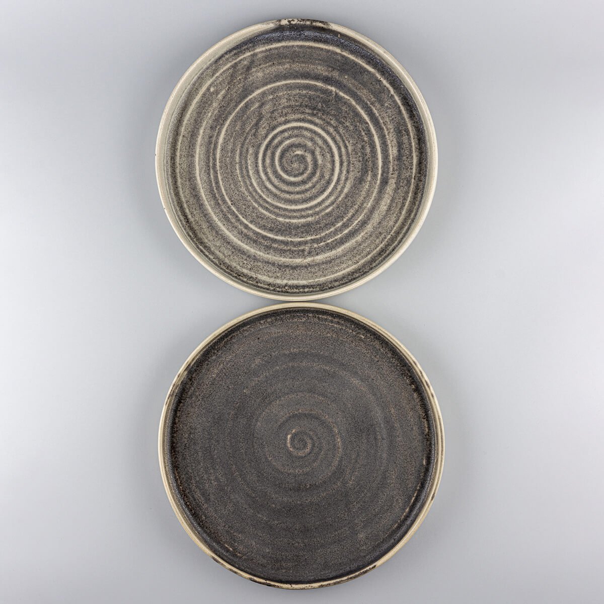 Elegant stoneware plates with artisanal spiral design, ideal for premium restaurants and home collections.