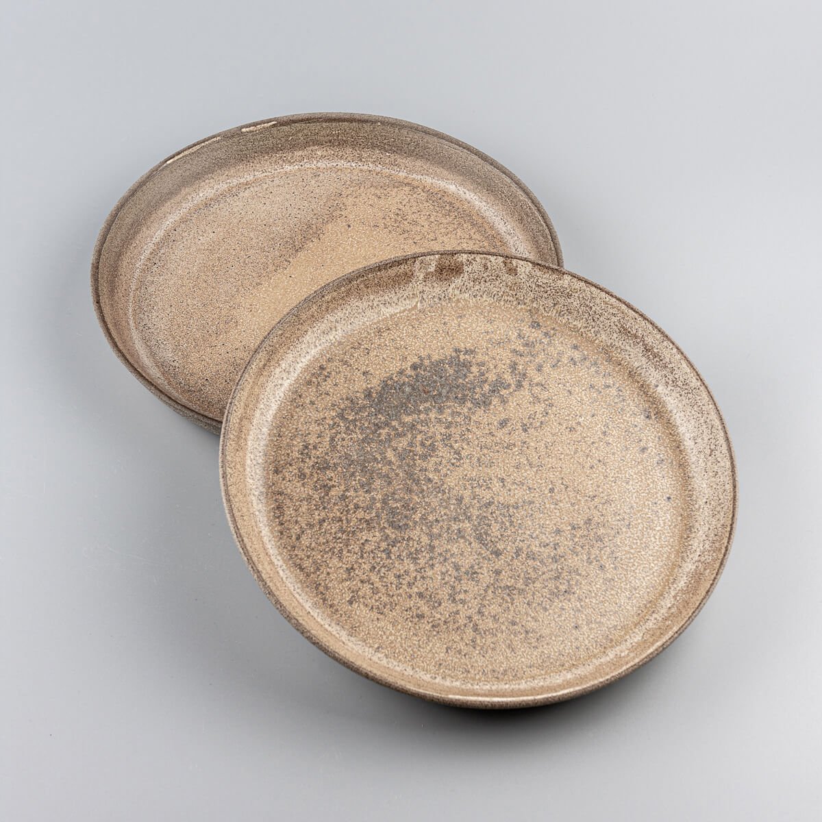 Handcrafted stoneware dinner plate set with matte ocher glaze for fine dining presentations.