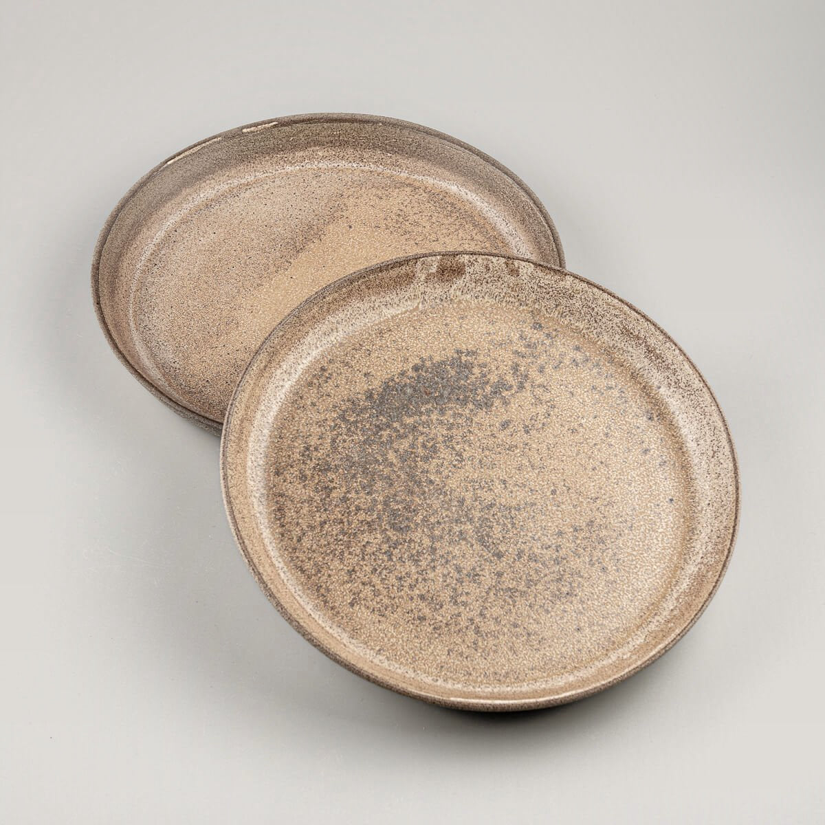 Handcrafted stoneware dinner plate set with matte ocher glaze for fine dining presentations.