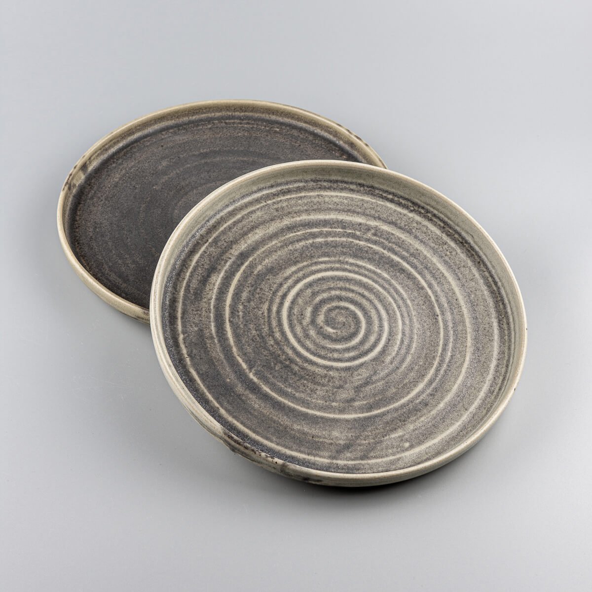Luxury handcrafted ceramic plate set with a spiral pattern and matte olive green glaze for fine dining.