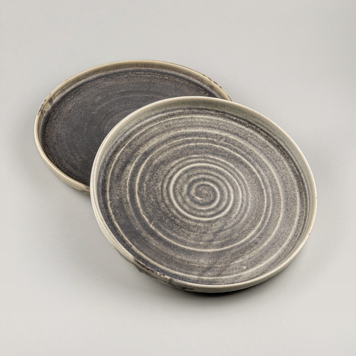 Luxury handcrafted ceramic plate set with a spiral pattern and matte olive green glaze for fine dining.