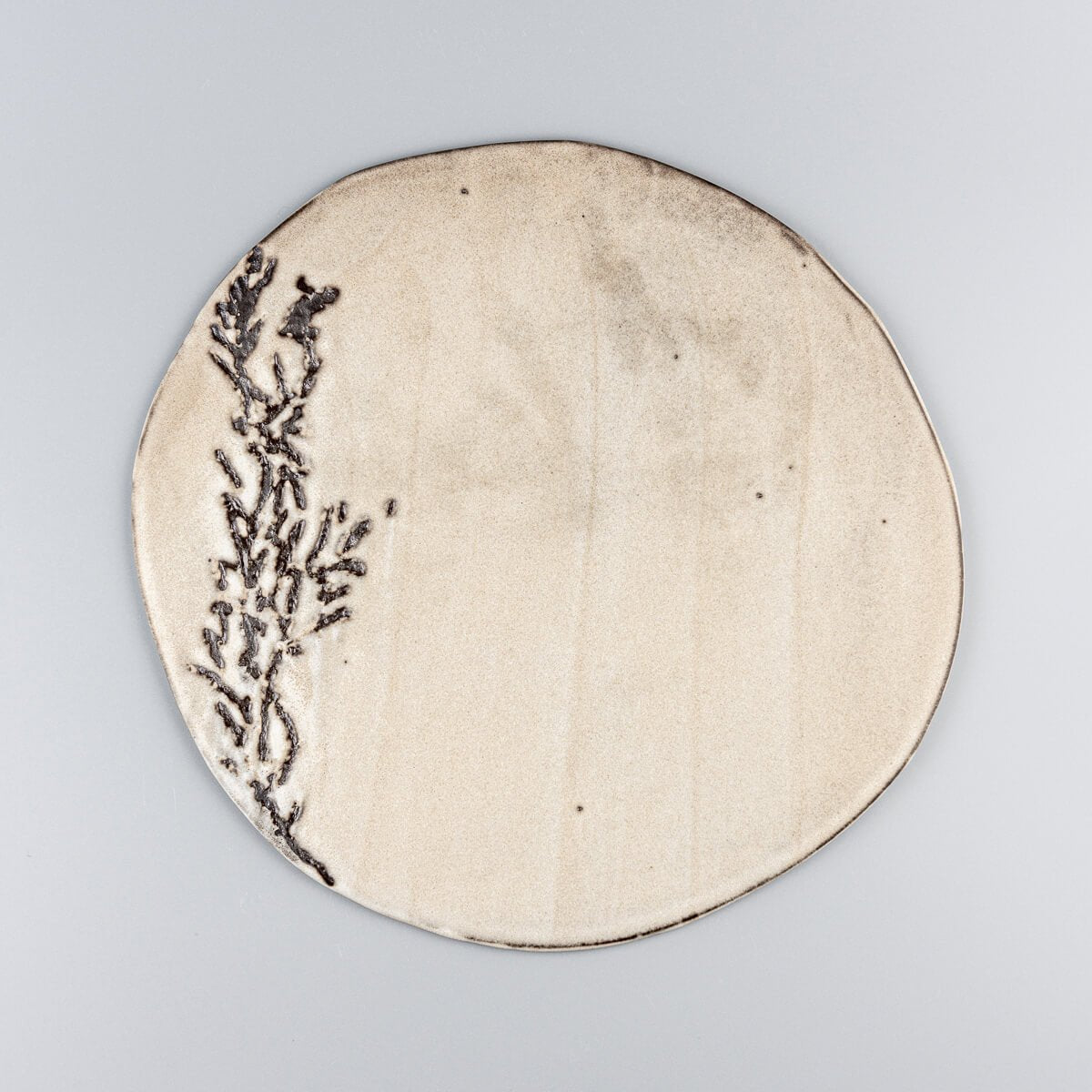 Flat white unique ceramic plate with hand-textured pattern for luxury dining presentation.