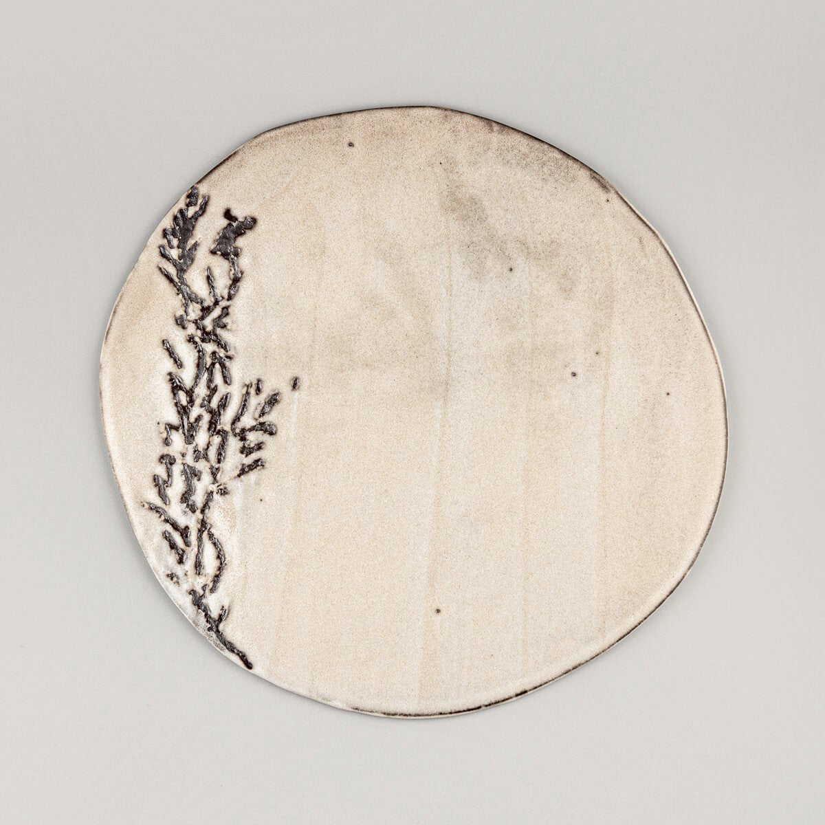 Flat white unique ceramic plate with hand-textured pattern for luxury dining presentation.