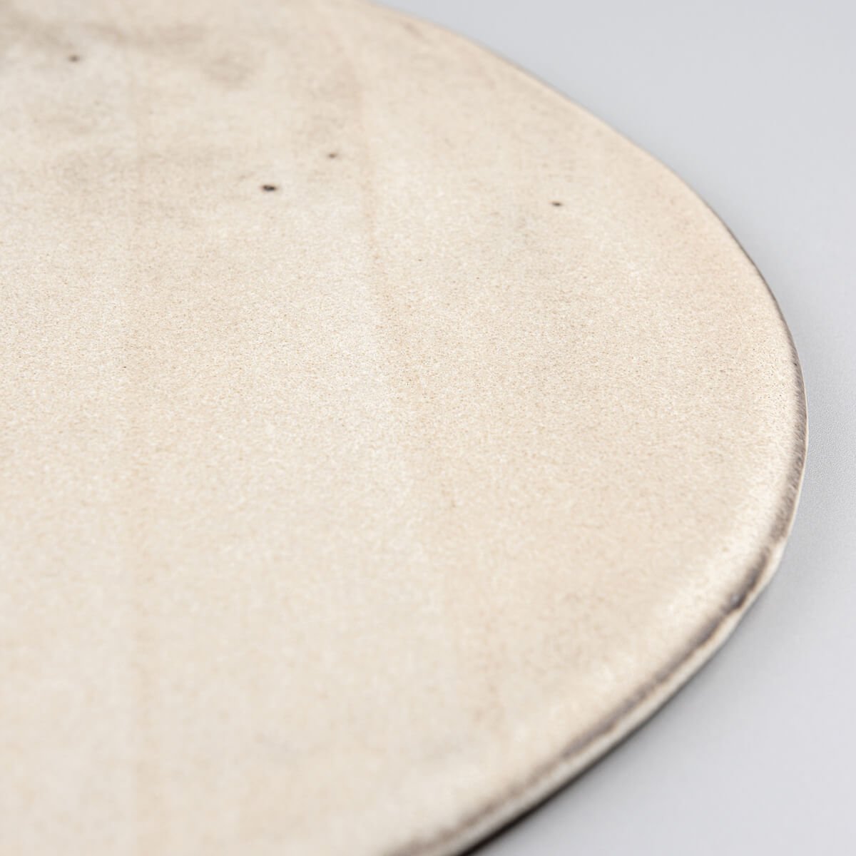 Minimalist flat ceramic plate with premium matte glaze for restaurant plating.