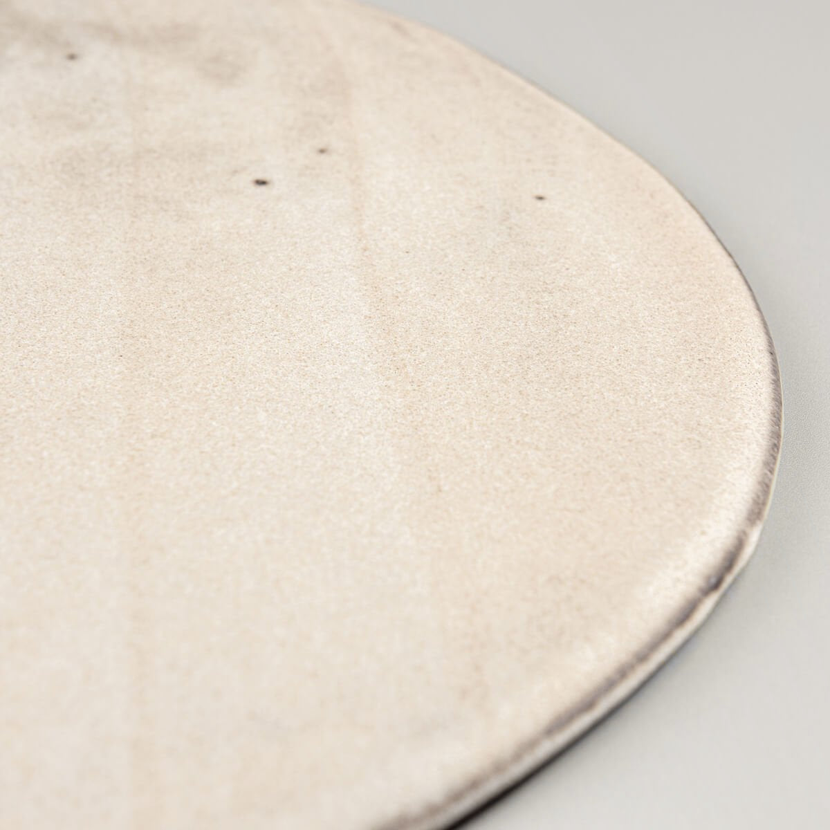 Minimalist flat ceramic plate with premium matte glaze for restaurant plating.