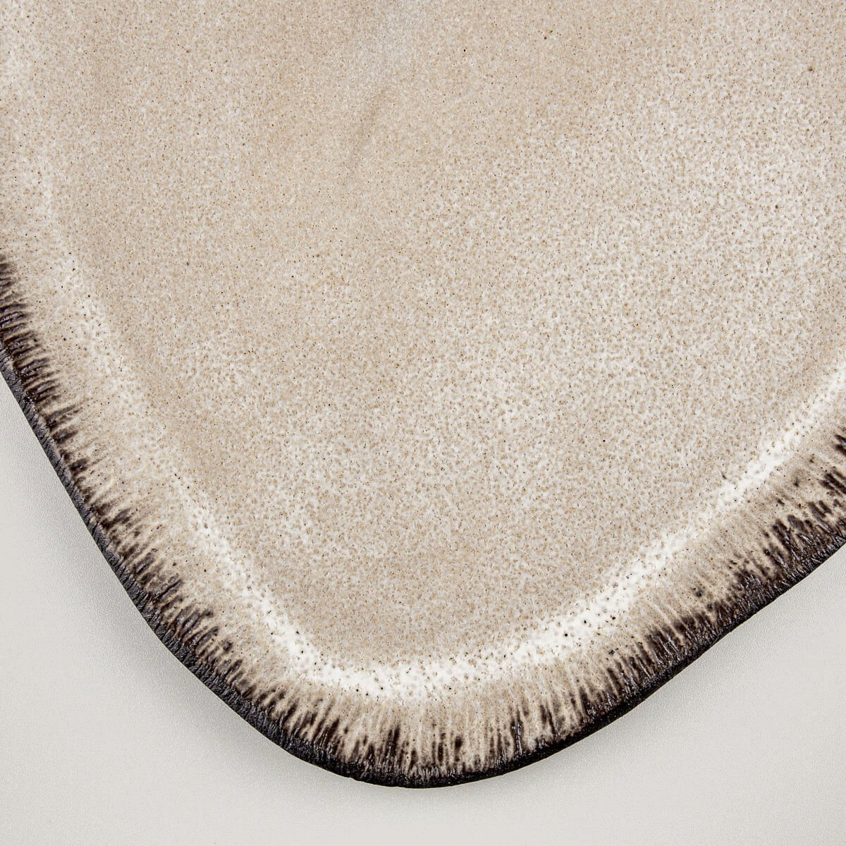 Artisan ceramic tableware with contrasting glaze and unglazed black stoneware base.