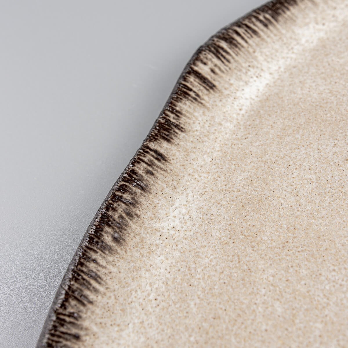 Textured ceramic plate rim with hand-applied detailing, ideal for luxury fine dining presentation.