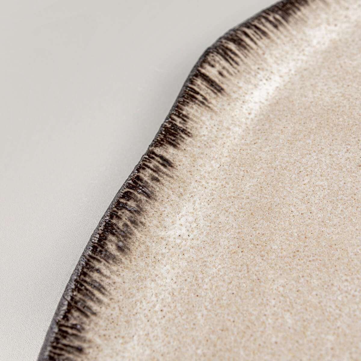 Textured ceramic plate rim with hand-applied detailing, ideal for luxury fine dining presentation.