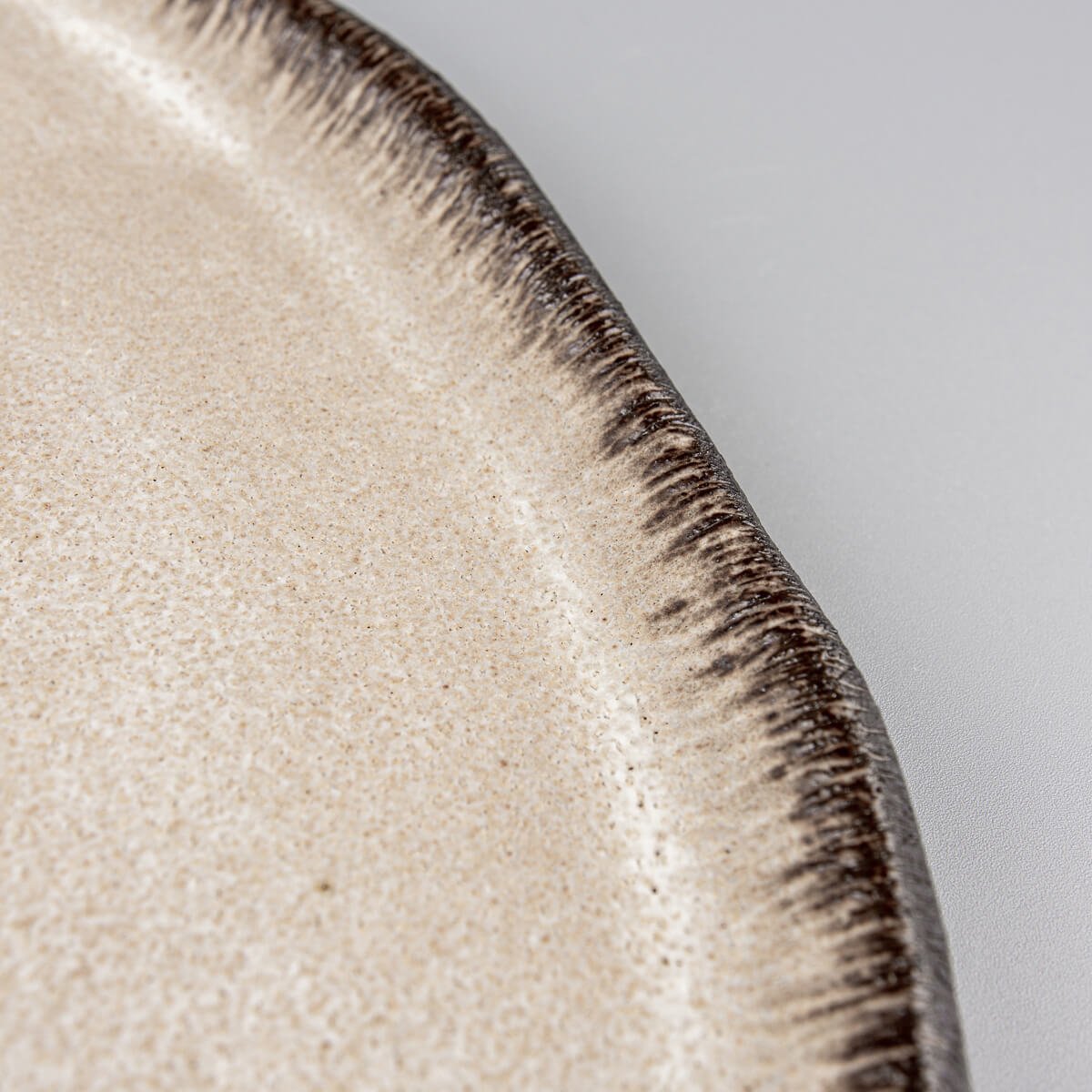 Close-up of artisan ceramic edge with contrasting glaze for premium culinary plating.