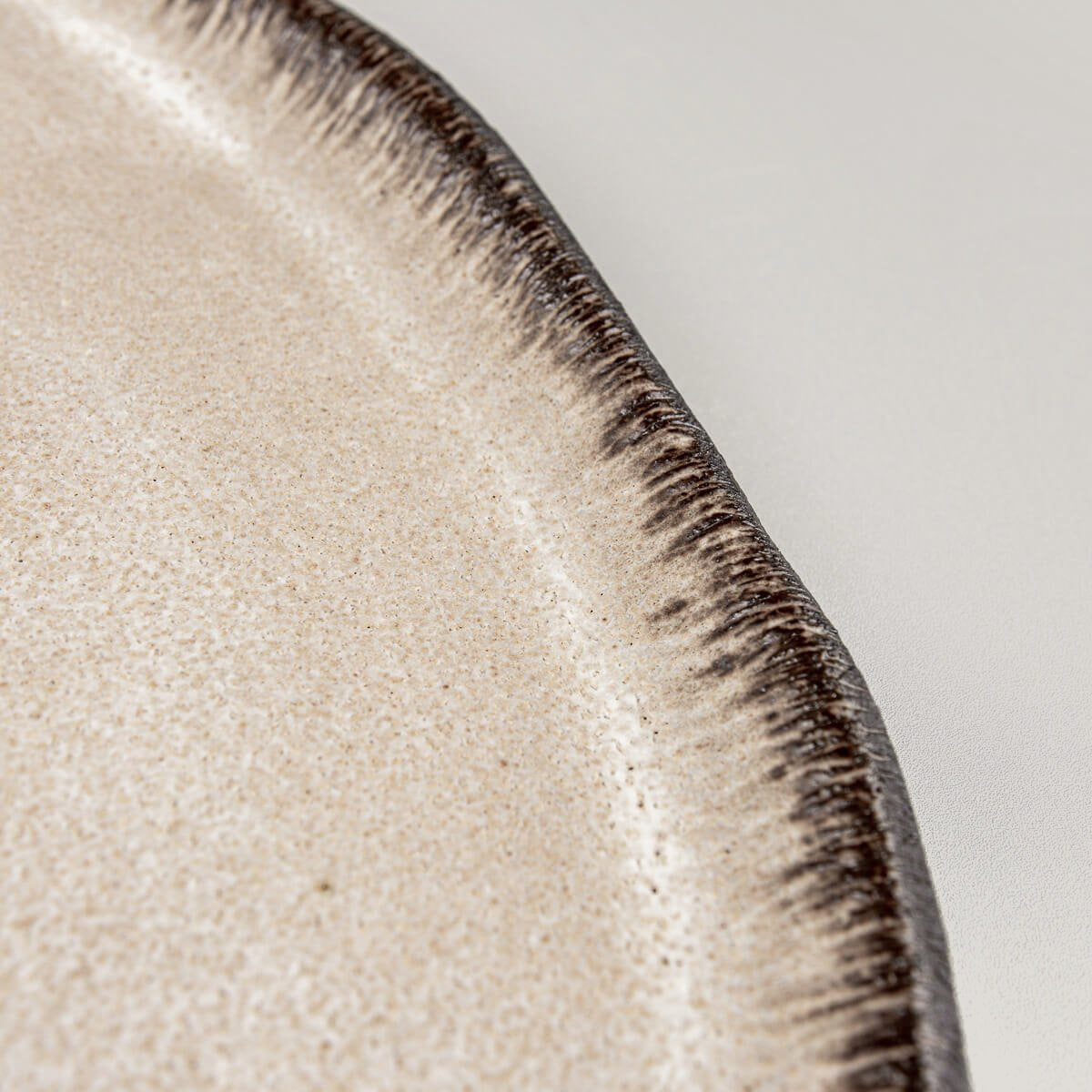 Close-up of artisan ceramic edge with contrasting glaze for premium culinary plating.