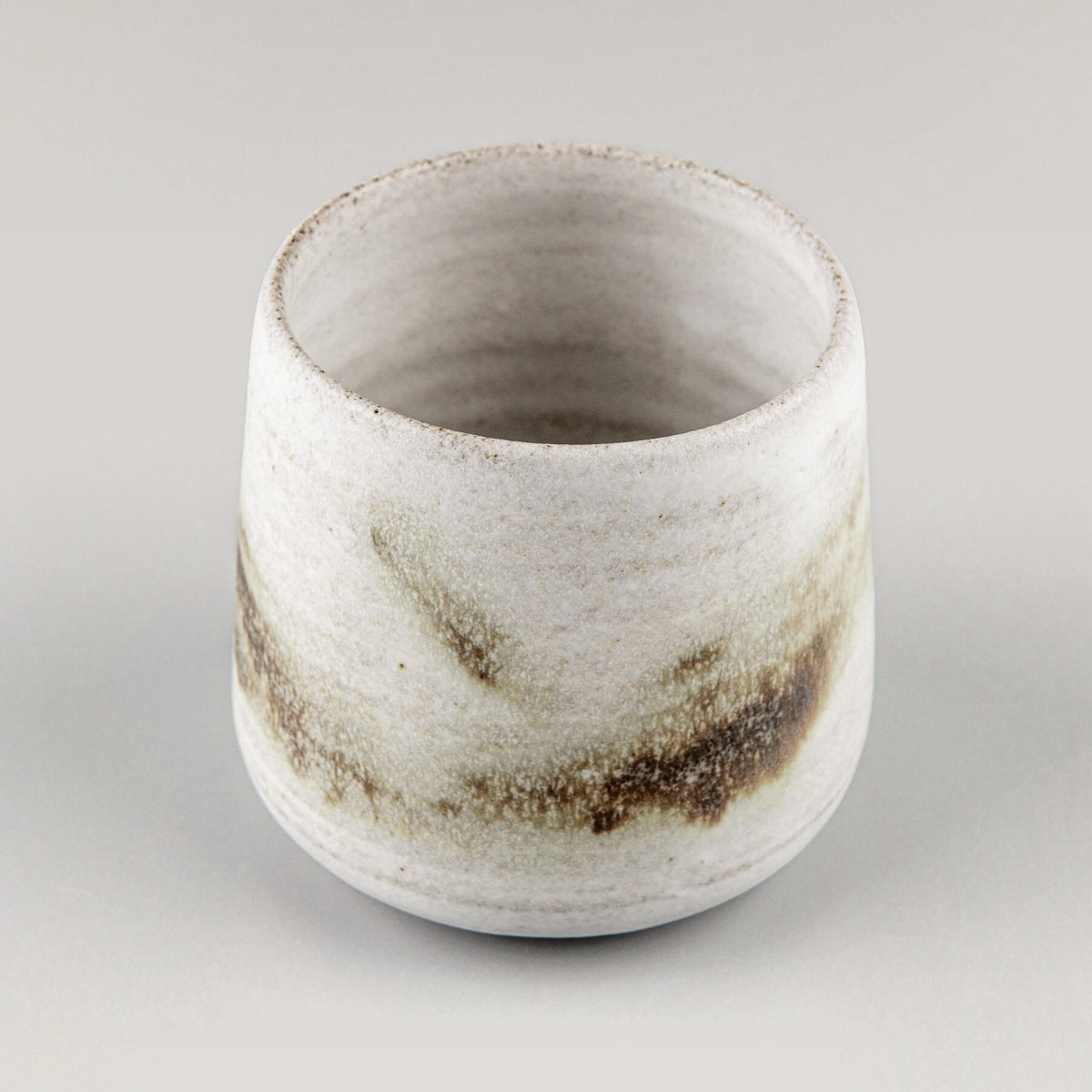 Top view of a handmade ceramic espresso cup with a unique glaze, perfect kitchenware for coffee lovers.