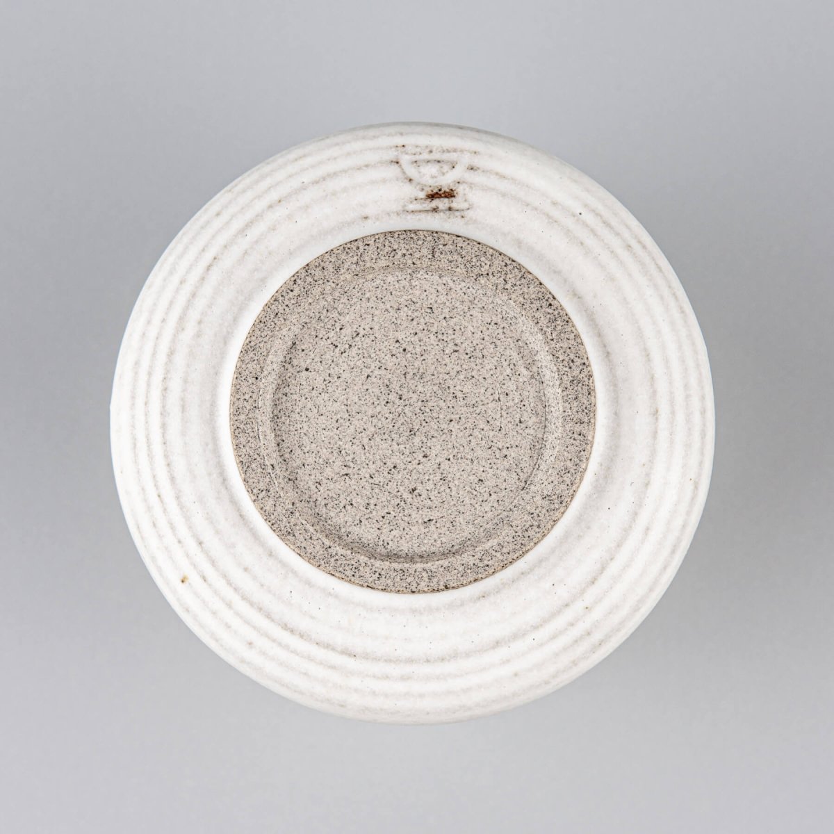 Base of ceramic espresso cup showing handcrafted stoneware texture for boutique hotel and home use.