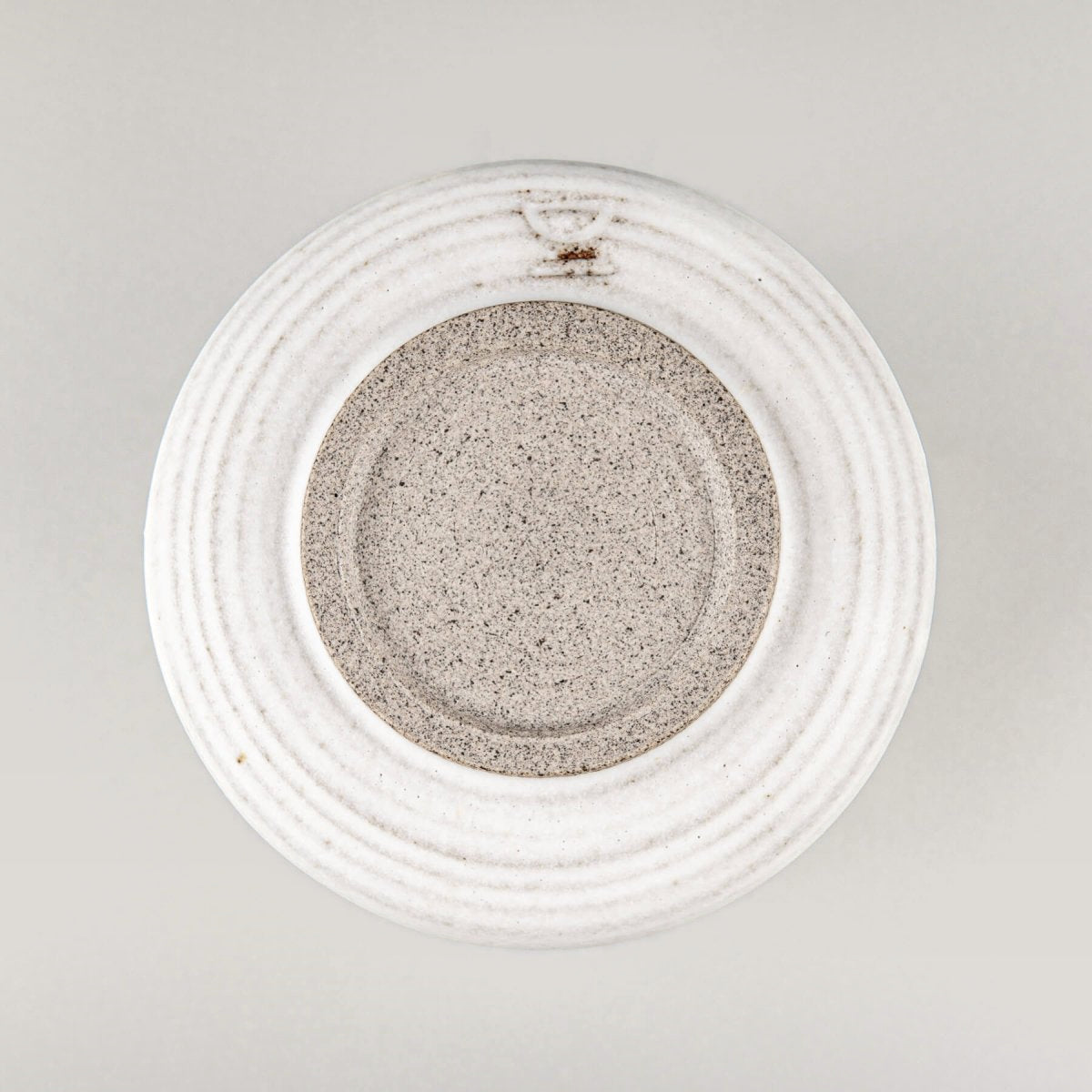 Base of ceramic espresso cup showing handcrafted stoneware texture for boutique hotel and home use.