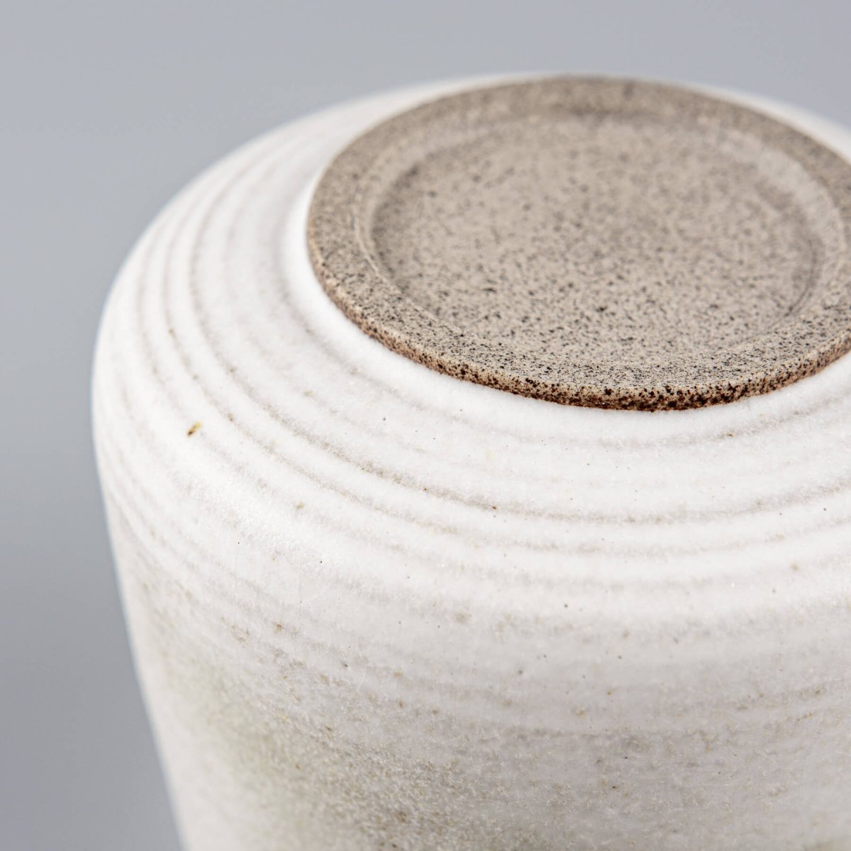 Detail of matte glaze with earthy copper tones on an espresso cup, ideal for collectible pottery displays.