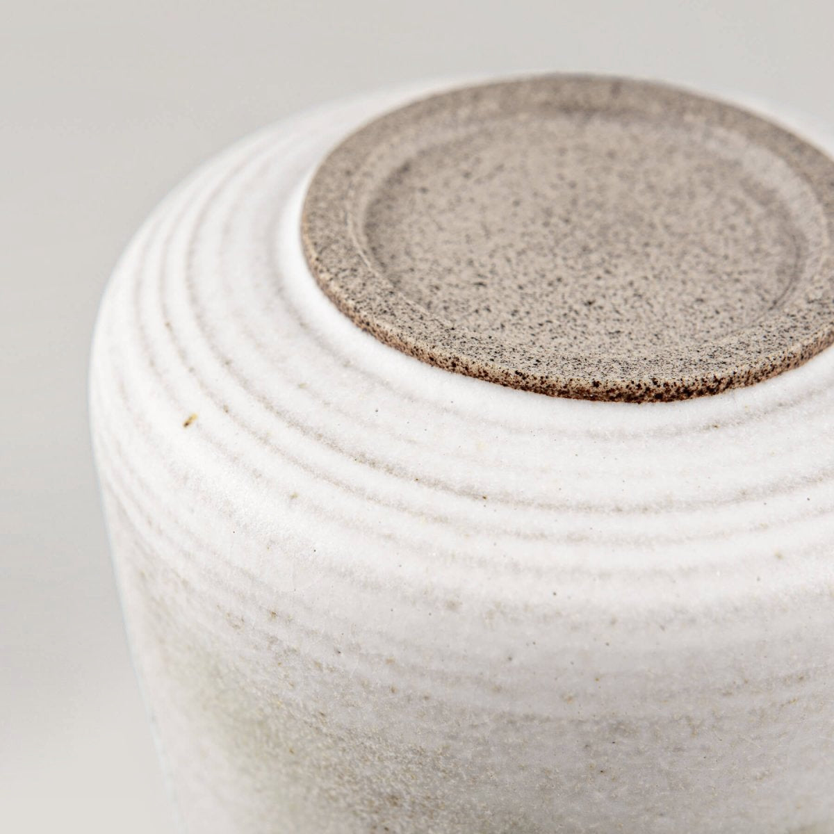 Detail of matte glaze with earthy copper tones on an espresso cup, ideal for collectible pottery displays.