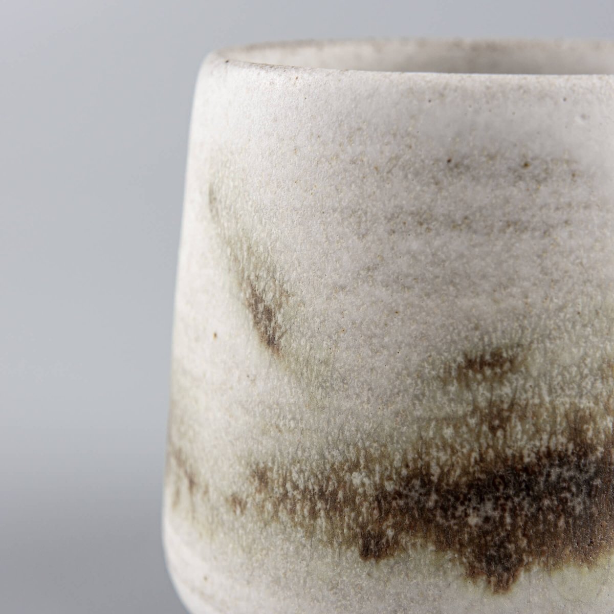Side view of espresso cup with subtle green and brown glaze accents, handmade kitchenware for gifting.